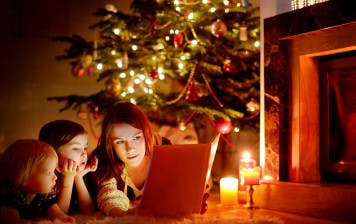 Mother and two young children reading Christmas books for kids